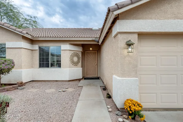 front view of a house with a big yard and potted plants