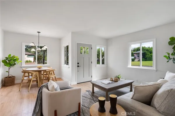 a dining room with furniture a potted plant and wooden floor
