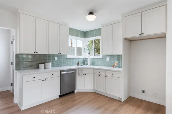 a kitchen with white cabinets and appliances