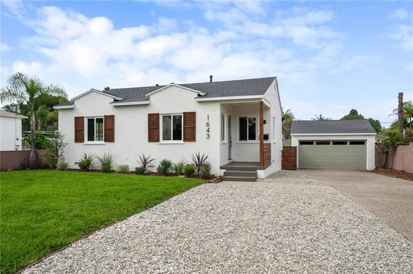 a front view of a house with a garden