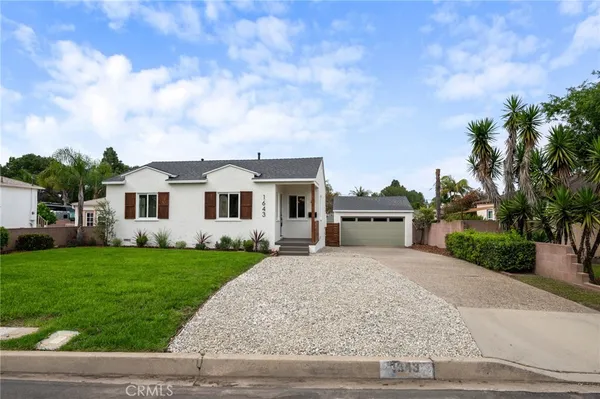 a front view of a house with a garden