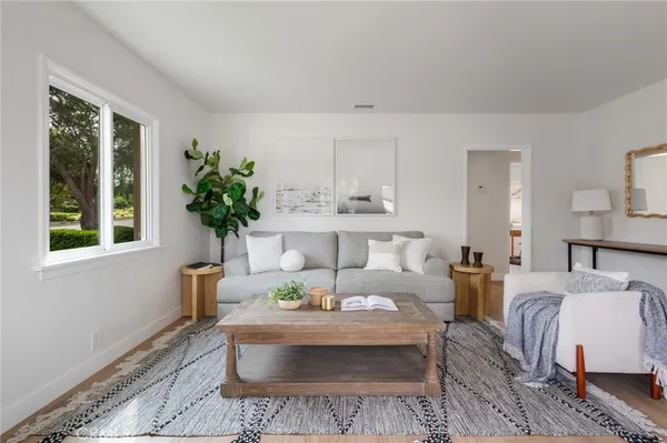 a living room with furniture and a wooden floor