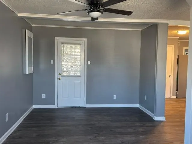 a view of an empty room with wooden floor