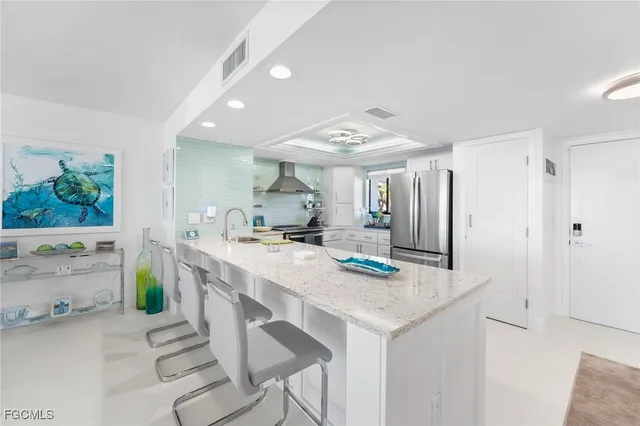 a kitchen with kitchen island a stove a refrigerator a sink dishwasher with a dining table and chairs