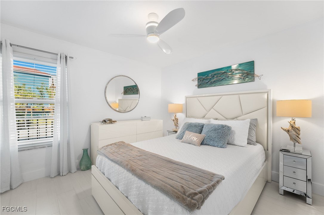 15010 Punta Rassa Road, Unit 106 Fort Myers, FL 33908 - Photo 19 of 36 a bedroom with a large bed and a chandelier