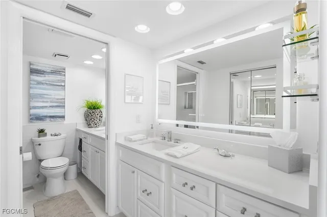 a bathroom with a granite countertop sink a toilet and shower