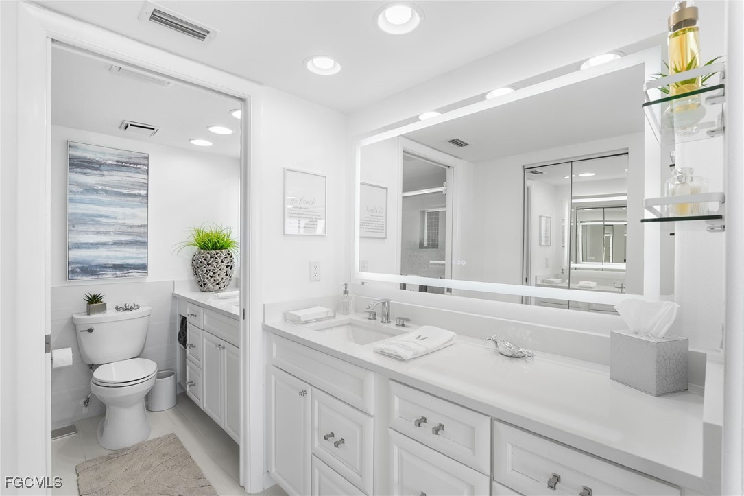 15010 Punta Rassa Road, Unit 106 Fort Myers, FL 33908 - Photo 22 of 36 a bathroom with a granite countertop sink a toilet and shower