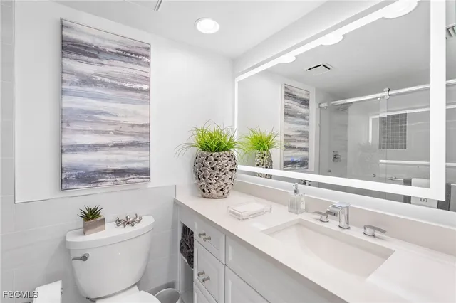 a bathroom with a sink toilet and window
