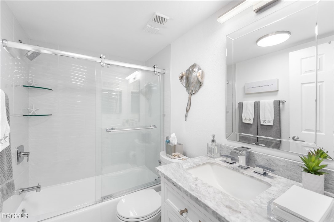 15010 Punta Rassa Road, Unit 106 Fort Myers, FL 33908 - Photo 24 of 36 a bathroom with a granite countertop sink toilet and shower