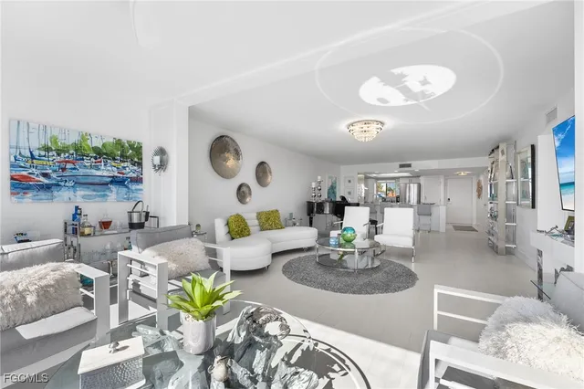 a living room with furniture kitchen and a chandelier