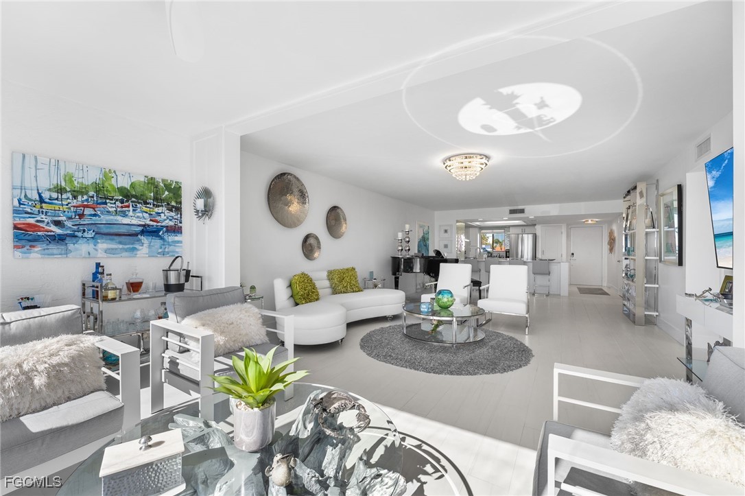 15010 Punta Rassa Road, Unit 106 Fort Myers, FL 33908 - Photo 8 of 36 a living room with furniture kitchen and a chandelier