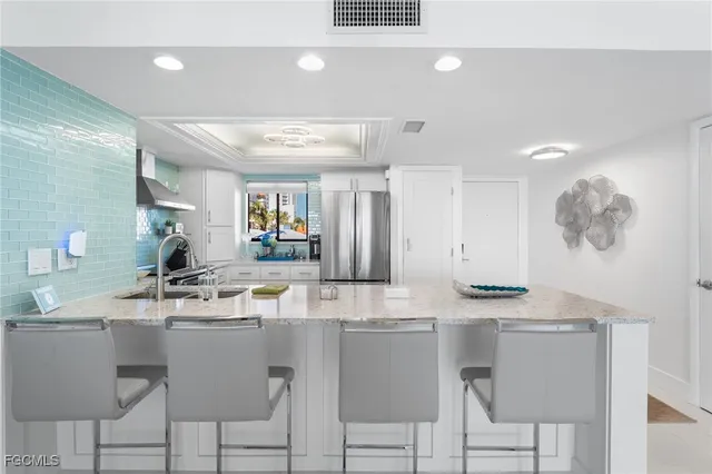 a room with stainless steel appliances kitchen island granite countertop a sink and cabinets