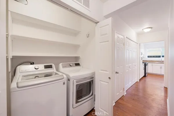 a view of washer and dryer with kitchen in the background