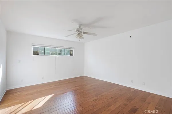a view of a big room with wooden floor and windows in a room