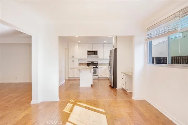 a view of kitchen dining table chairs microwave and refrigerator