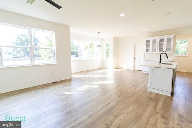 a large white kitchen with kitchen island a sink a stove and refrigerator