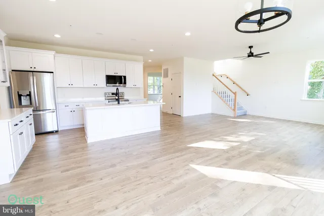 a kitchen with a sink appliances cabinets and a window