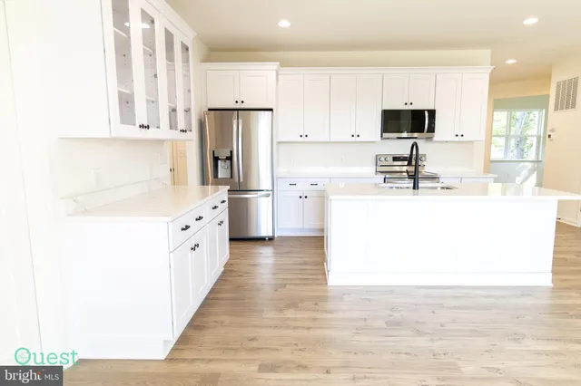 a kitchen with a stove a sink and cabinets
