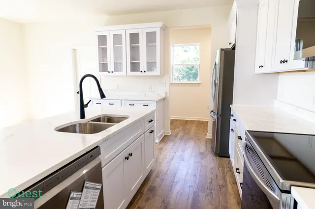 a view of a refrigerator in kitchen and an empty room