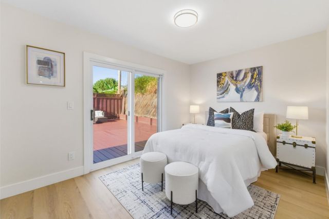 a spacious bedroom with a bed and wooden floor
