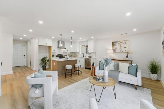 a living room with furniture and a dining table with kitchen view