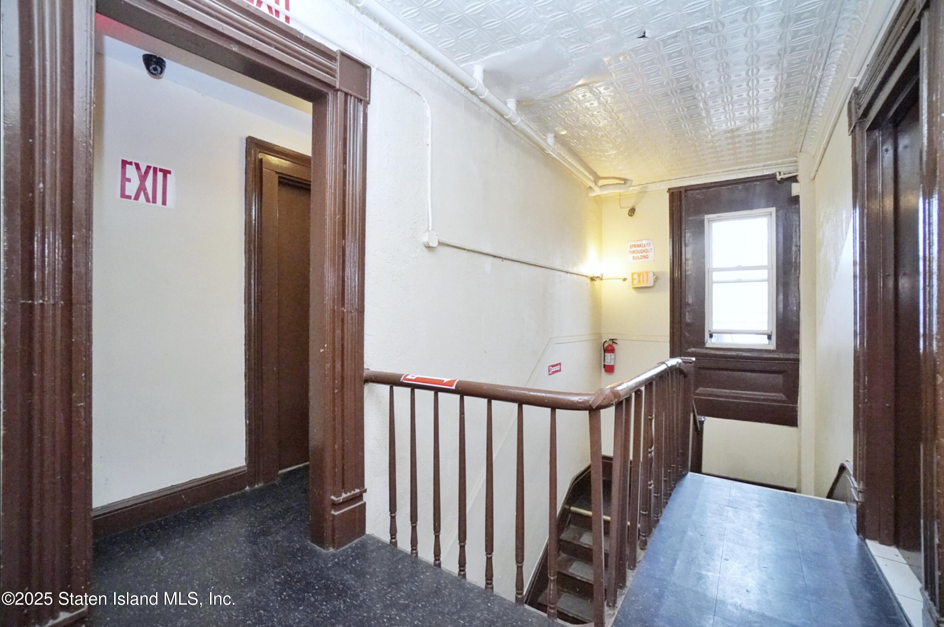 90 Vreeland Street Staten Island, NY 10302 - Photo 16 of 25 a view of a hallway to a livingroom with wooden floor and stairs
