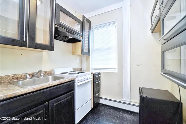 a kitchen with a sink cabinets appliances and a window