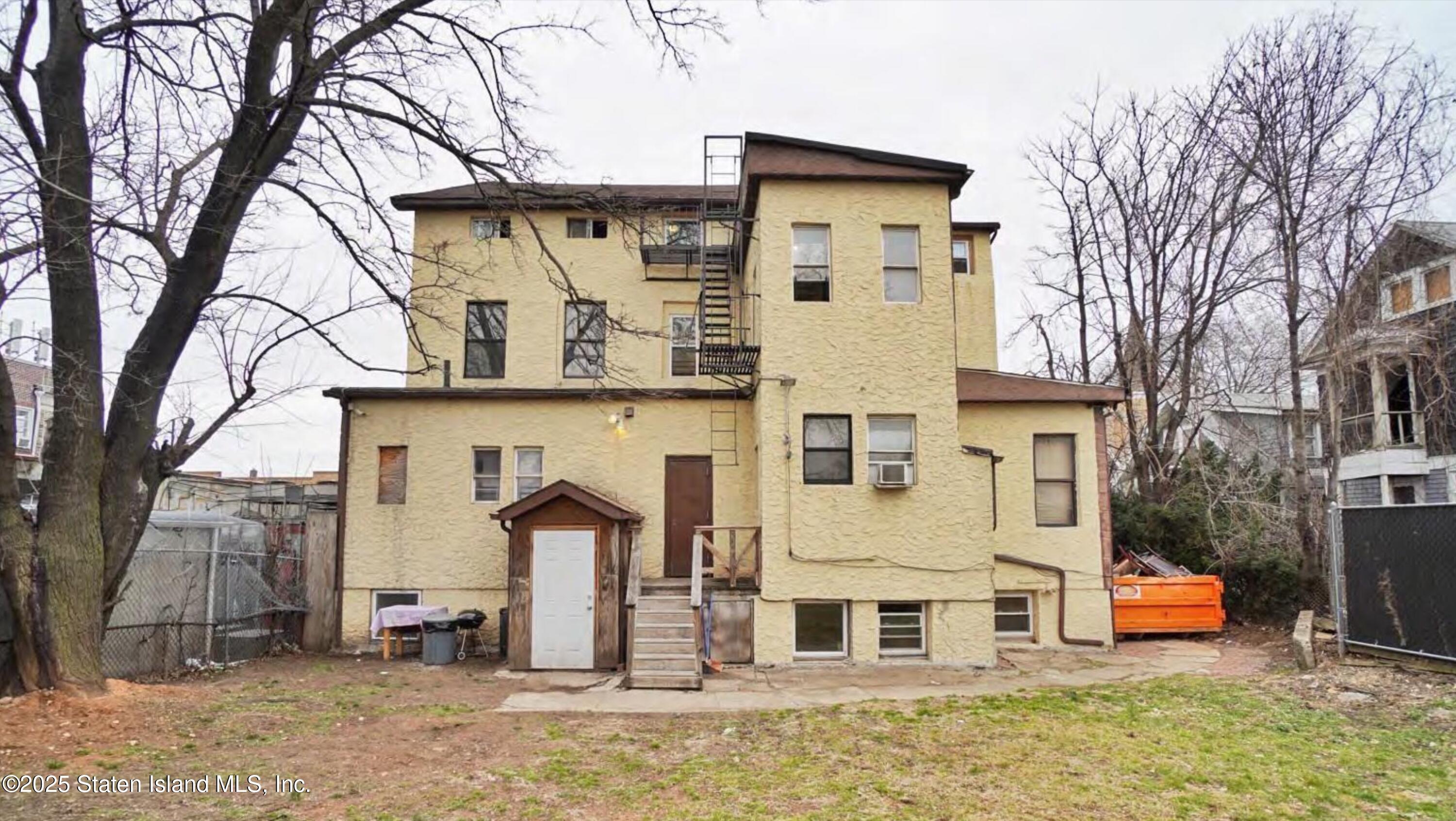 90 Vreeland Street Staten Island, NY 10302 - Photo 10 of 25 a view of a white house with a large tree and wooden fence