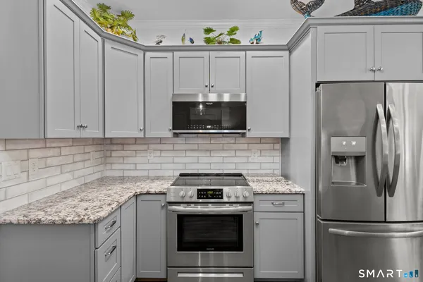 a kitchen with stainless steel appliances granite countertop a refrigerator stove a sink and dishwasher