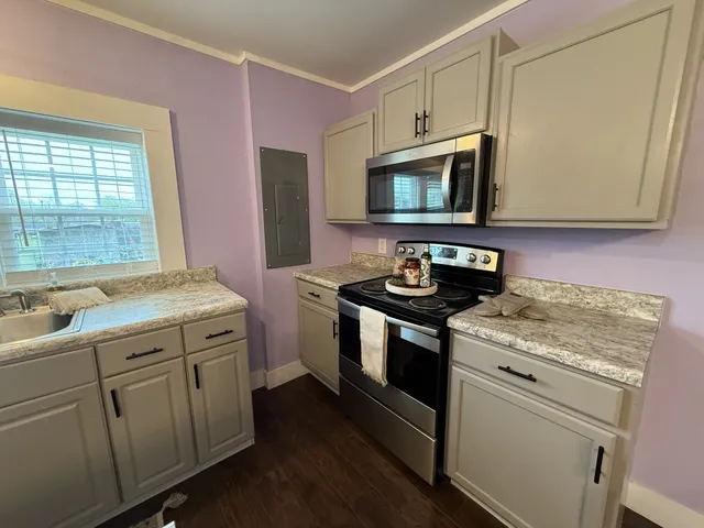 a kitchen with stainless steel appliances granite countertop a stove a sink and a microwave