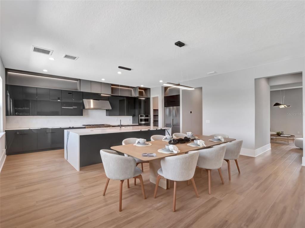 16808 Bolsena Drive Montverde, FL 34756 - Photo 27 of 68 a kitchen with a dining table chairs and wooden floor