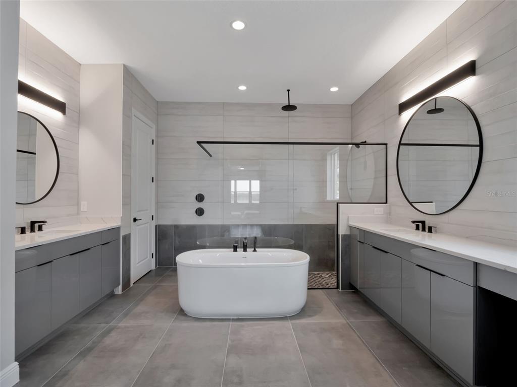 16808 Bolsena Drive Montverde, FL 34756 - Photo 38 of 68 a spacious bathroom with a double vanity sink double mirror and bathtub