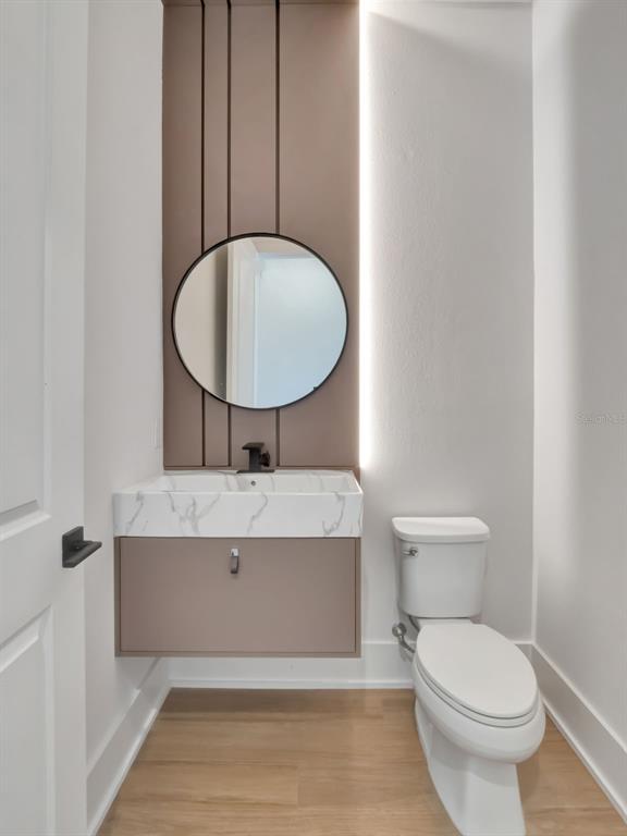 16808 Bolsena Drive Montverde, FL 34756 - Photo 44 of 68 a bathroom with a toilet a sink and mirror