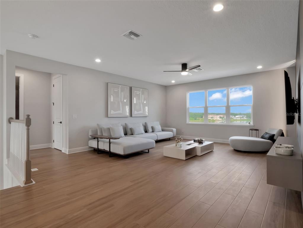 16808 Bolsena Drive Montverde, FL 34756 - Photo 47 of 68 a living room with furniture and a flat screen tv