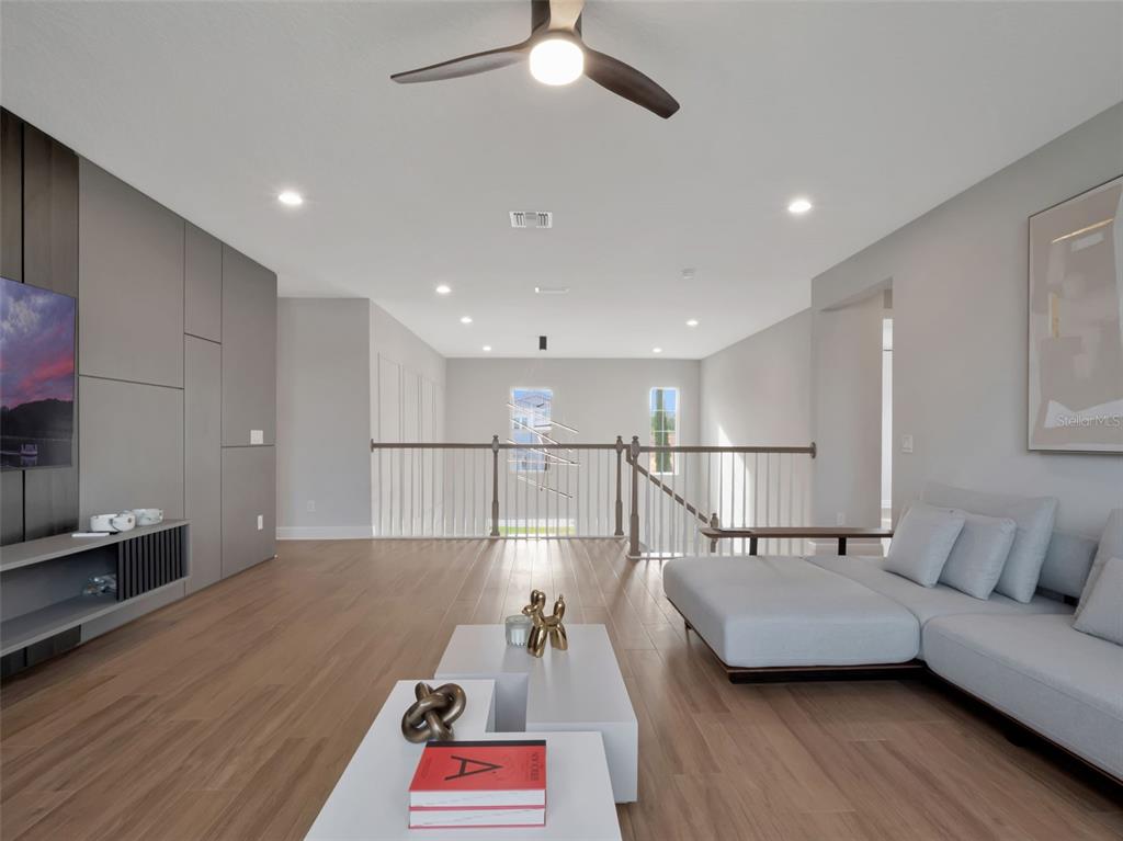 16808 Bolsena Drive Montverde, FL 34756 - Photo 48 of 68 a living room with furniture and a wooden floor