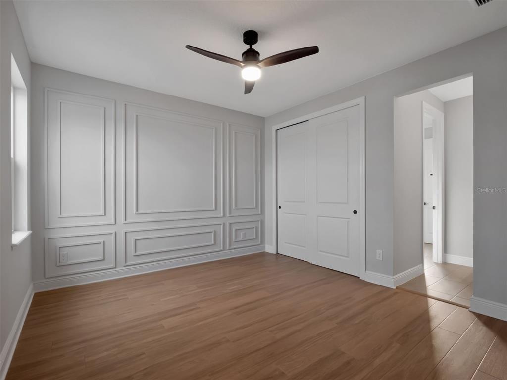 16808 Bolsena Drive Montverde, FL 34756 - Photo 49 of 68 a view of empty room with wooden floor and ceiling fan