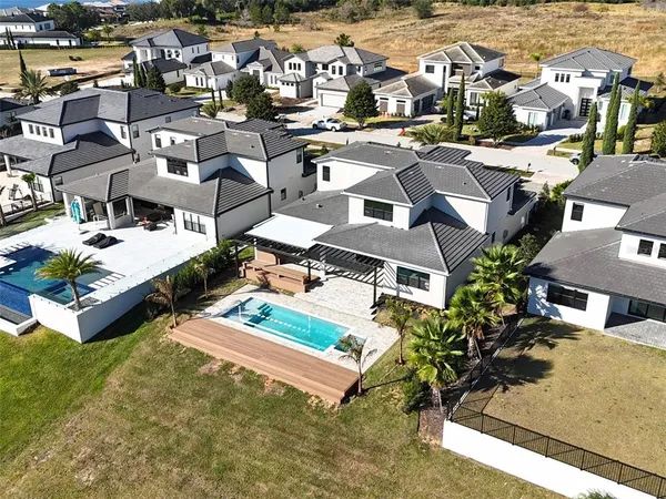 an aerial view of a residential houses with outdoor space and ocean view