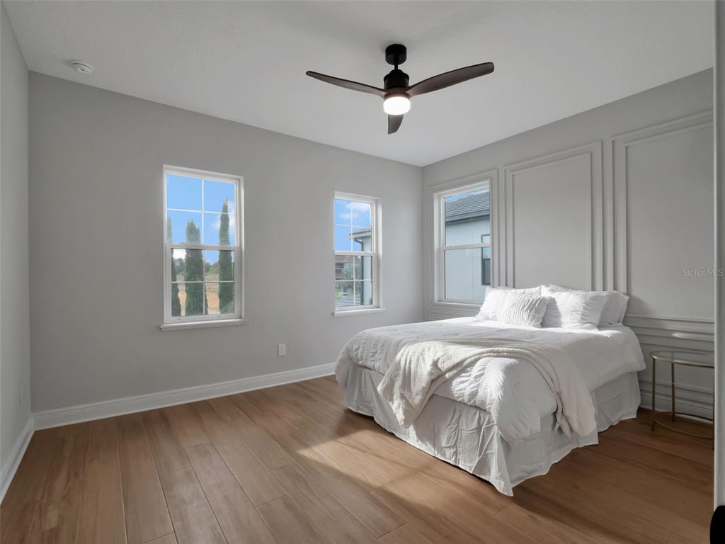 16808 Bolsena Drive Montverde, FL 34756 - Photo 51 of 68 a bedroom with a large bed chandelier and a window