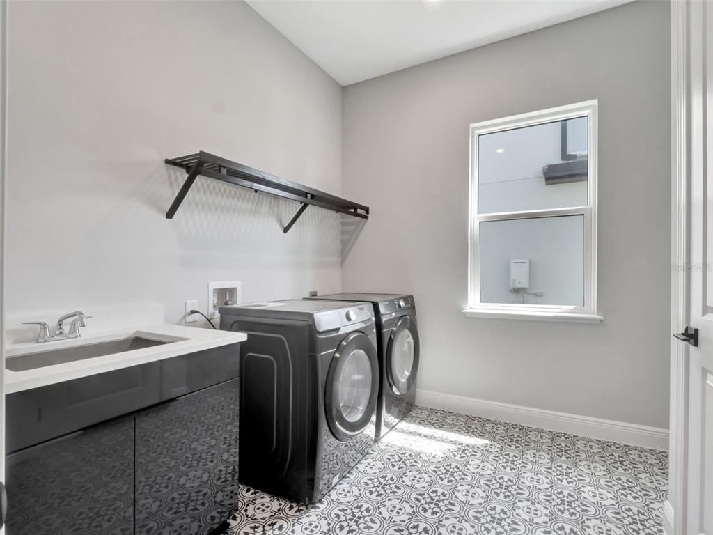 16808 Bolsena Drive Montverde, FL 34756 - Photo 54 of 68 a utility room with a sink a washer and dryer