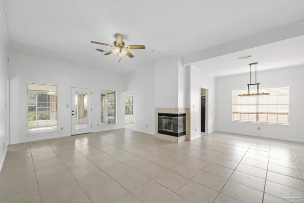 a view of an empty room with a kitchen and window