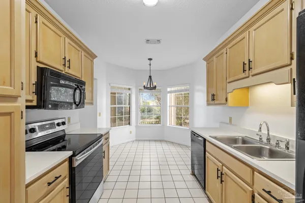 a kitchen with a sink stove top oven and refrigerator