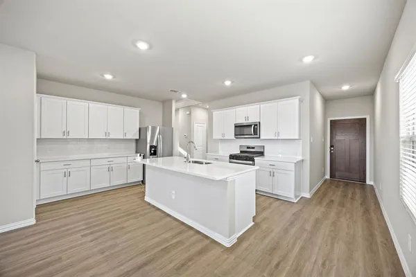 a kitchen with white cabinets and stainless steel appliances