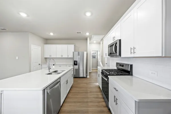 a kitchen with a sink a stove top oven and white kitchen