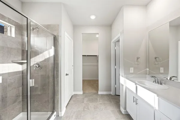 a bathroom with a double vanity sink mirror and shower