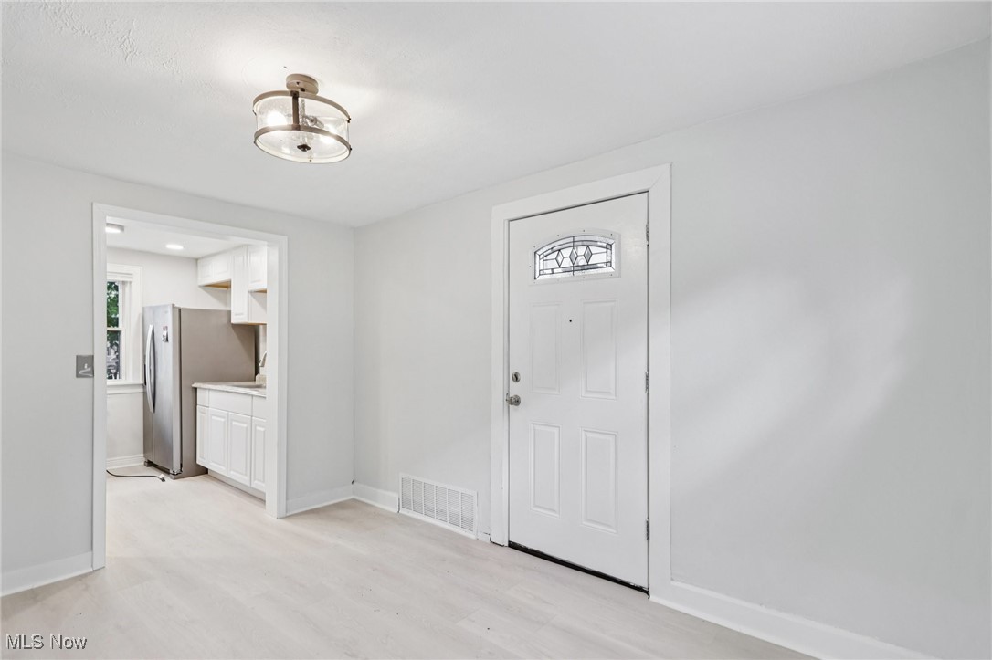1469 South Noble Road Cleveland, OH 44121 - Photo 9 of 29 Entryway featuring light wood-style floors and baseboards