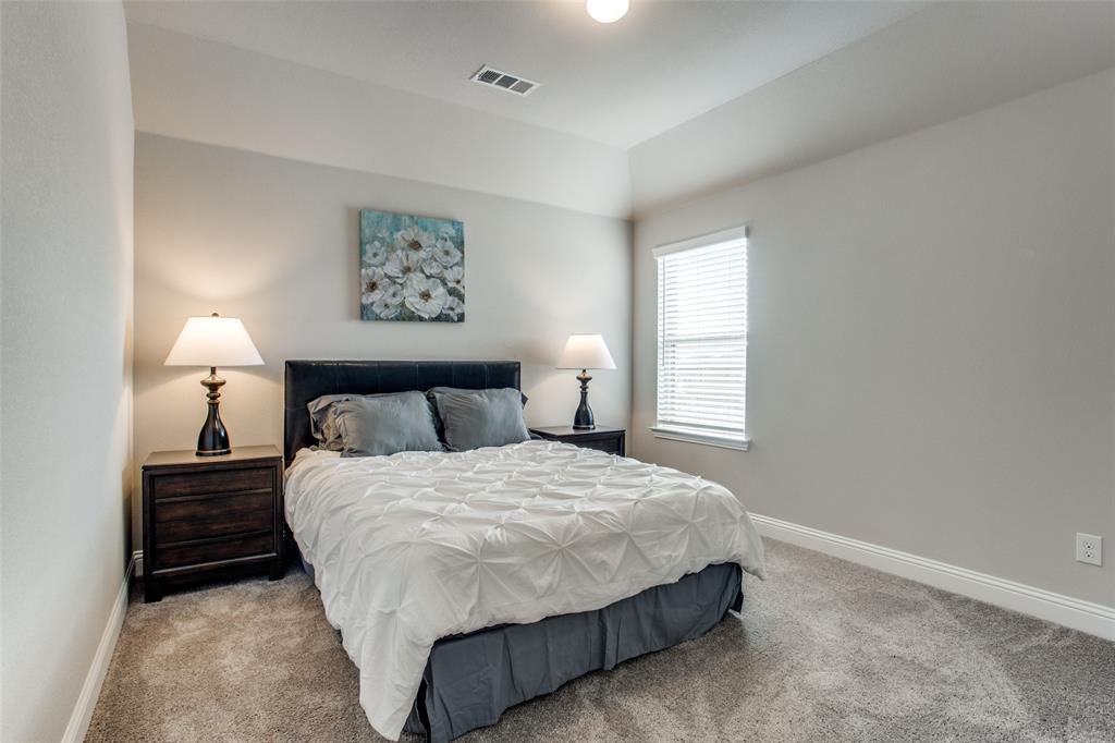 1718 Lisa Court Allen, TX 75002 - Photo 22 of 26 a bedroom with a bed and a lamp on dresser