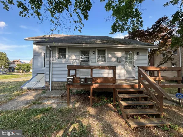 a view of a house with a wooden deck and a lawn chairs