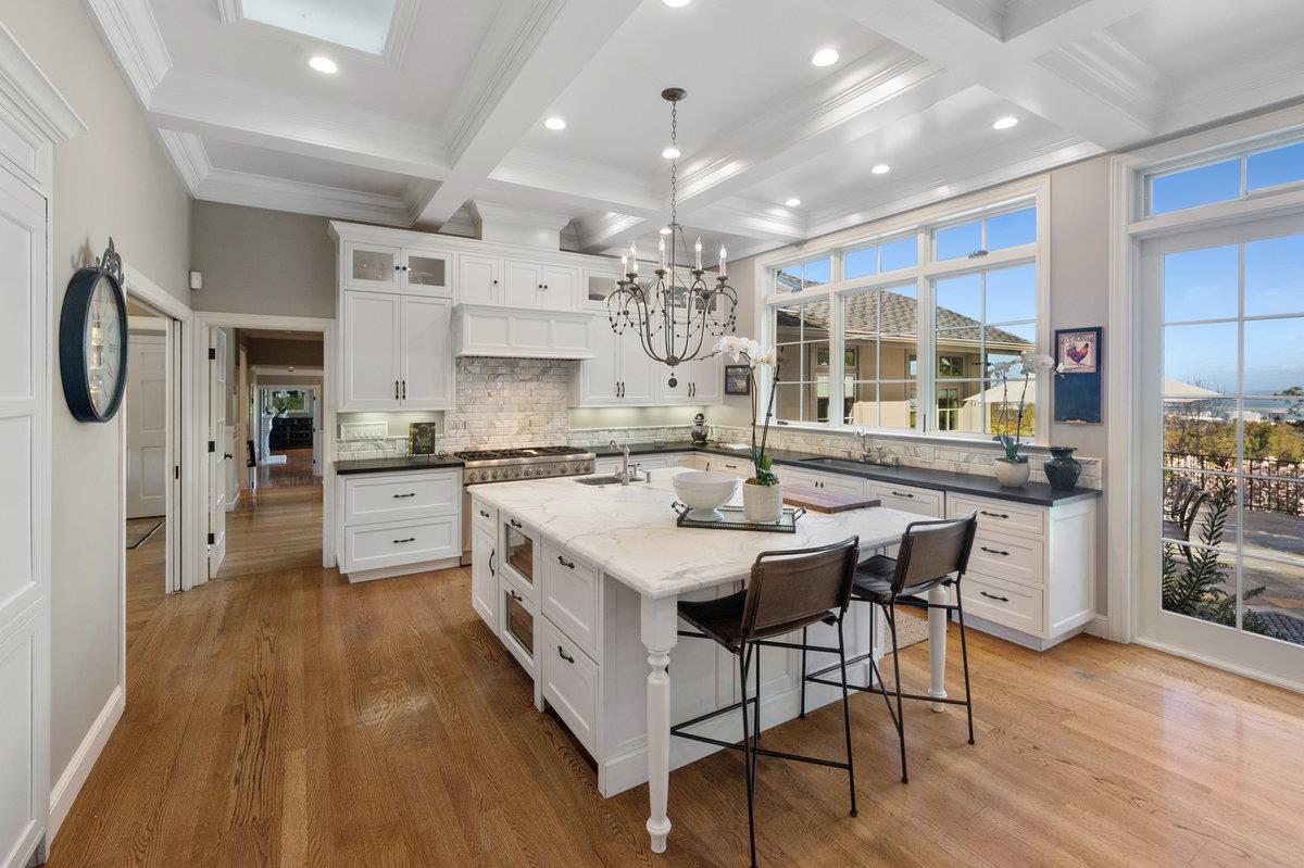 714 Jacaranda Circle Hillsborough, CA 94010 - Photo 4 of 57 a kitchen with stainless steel appliances kitchen island granite countertop a table chairs in it and wooden floors