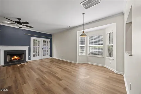 a view of an empty room with window and wooden floor