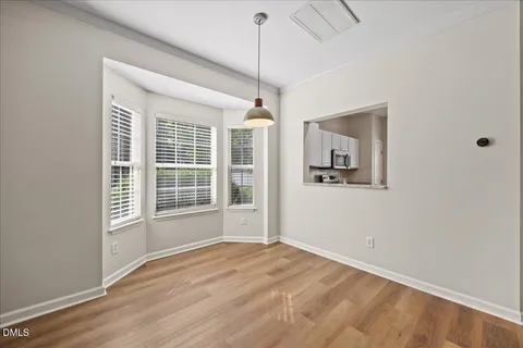 a view of empty room with wooden floor and ceiling fan